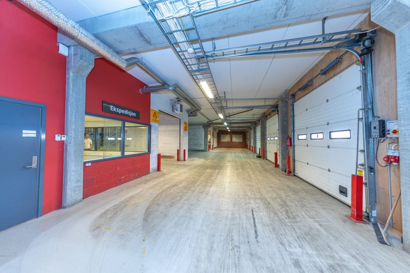 Det er et ekspedisjonsrom mellom varemottak og lagerareal